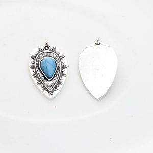 Detailed view of silver ethnic water drop pendants with turquoise resin and engravings
