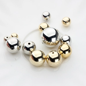 Macro view of polished gold and silver CCB beads with central holes for jewelry making