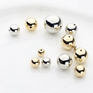 Close-up of polished gold and silver CCB beads with smooth mirror finish for DIY jewelry