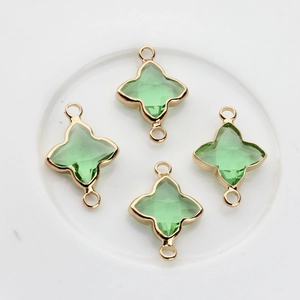 Détail de breloques trèfle en cristal vert clair avec anneaux dorés pour bijoux artisanaux