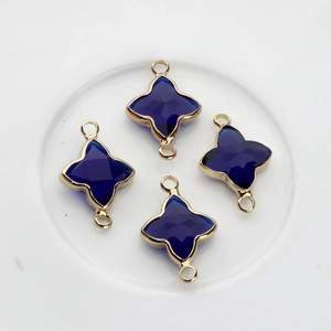 Détail de 4 breloques étoile en cristal bleu foncé avec bordure dorée et doubles boucles