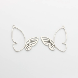 Detailed macro view of asymmetric hollow butterfly alloy charms in high-shine silver finish