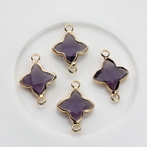 Gros plan de breloques trèfle en cristal violet plaqué or pour bijoux artisanaux
