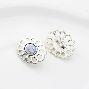 Macro shot of silver alloy flower buttons with white faux stone and sewing loop