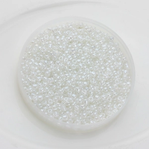 Macro detail of 2mm pearl white glass seed beads in a tray for DIY jewelry making