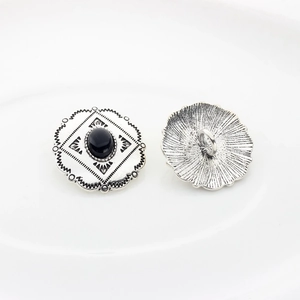 Detail of vintage silver alloy buttons with black oval stone and carved floral edges