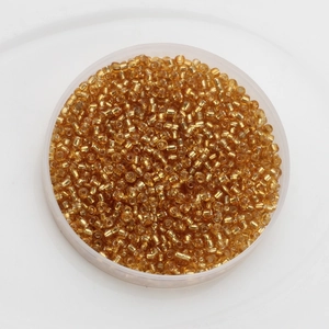 Macro view of 2mm silver-lined glass seed beads in a round transparent container