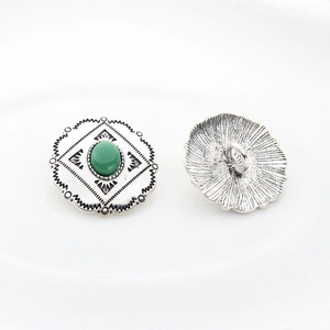 Detail of vintage silver alloy floral buttons with green gemstone inlay for DIY jewelry