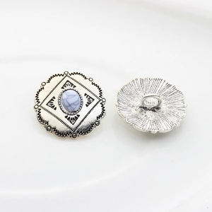 Close-up of vintage silver alloy buttons with white stone center showing front and back
