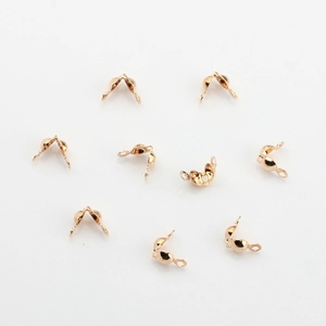 Macro detail of rose gold DIY jewelry folding crimp bead covers and metal cord ends