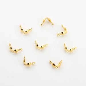 Macro detail of golden half-round jewelry crimp bead covers for DIY jewelry making