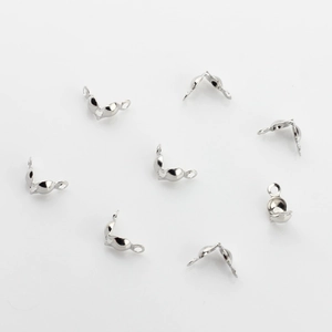 Macro detail of silver folding crimp bead covers and jewelry wire connectors for DIY