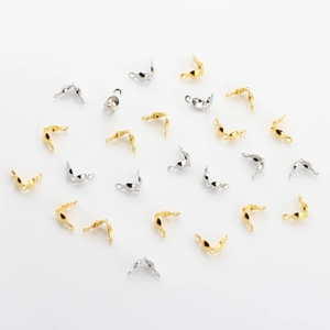 Detail of gold and silver shell-shaped bead tips for DIY jewelry making and wire finishing