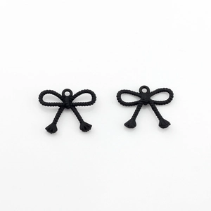 Detail view of black matte bow pendants with rope texture for DIY earring making