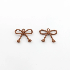Macro detail of two brown bow pendants with rope texture for DIY jewelry making