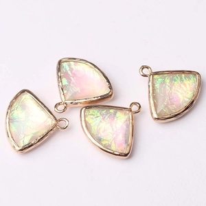 Macro detail of four fan-shaped iridescent crystal pendants with gold metal frames