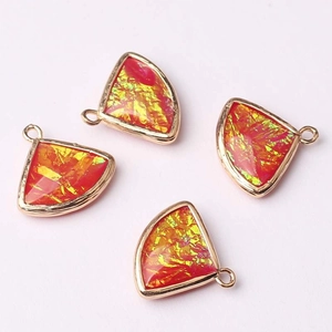 Detailed view of four fan-shaped glass crystal charms with gold edges for jewelry making