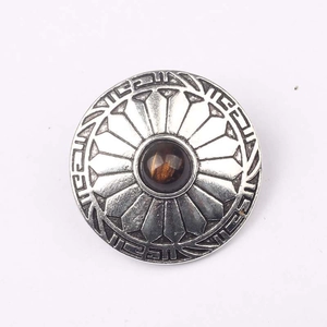 Macro view of vintage silver floral round zinc alloy button with brown tiger eye bead