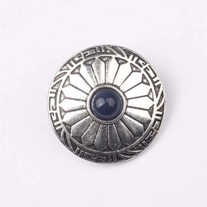 Detailed view of vintage zinc alloy flower button with center blue cabochon gem