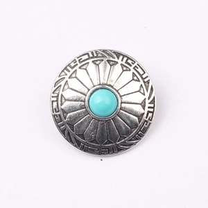Macro detail of retro zinc alloy button with turquoise inlay and boho engraving
