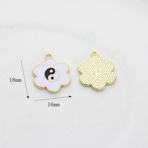 Detail of 18mm flower-shaped yin yang charms with gold plating and enamel inlay
