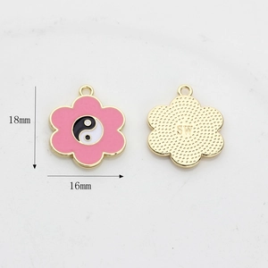 Detailed view of 18mm pink enamel flower heart tai chi charm with golden back