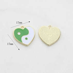 Macro detail of heart-shaped tai chi pendant showing green enamel inlay and 17mm size dimensions