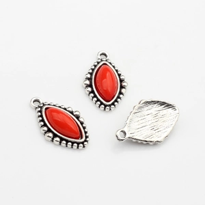 Detailansicht der vintage silberfarbenen Ösenanhänger mit roter Harzfüllung für Schmuck