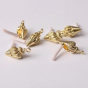 Détails macro de breloques en forme de conque dorée pour la création de bijoux DIY