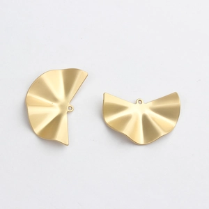 Detailed view of golden semi-circular fan charms with wave texture for DIY jewelry making