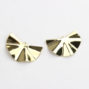 Macro view of gold-plated fan-shaped charms with pleated texture for DIY jewelry making