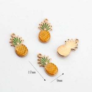 Detailed macro view of 17x9mm pineapple charms with yellow enamel and golden alloy