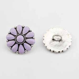 Vue macro d'un bouton marguerite vintage en émail lilas avec dos à tige en métal argenté