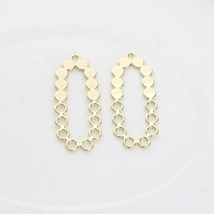 Detail of two golden hollow oval pendants with metallic bead edges for DIY jewelry making