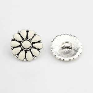 Détail de boutons marguerite argentés à 12 pétales avec boucle de couture au dos