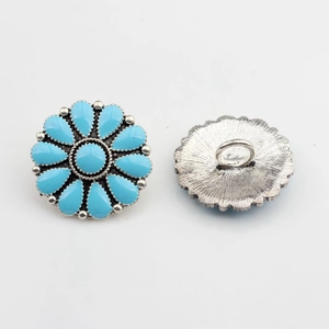 Détail du bouton marguerite vintage avec pierres turquoises et attache métallique arrière