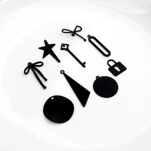 Détail de divers pendentifs de bijoux DIY noir mat incluant des étoiles et des nœuds