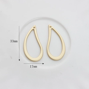Detail view of teardrop geometric alloy charms in matte gold finish for DIY jewelry