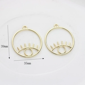 Vue détaillée des pendentifs œil creux avec mesures de 39 mm de haut et 35 mm de large