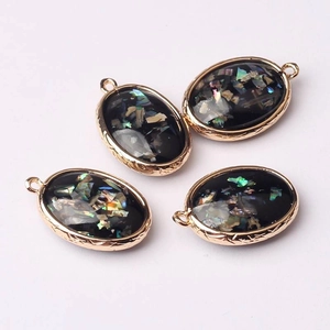 Detailed view of oval iridescent abalone shell charms with woven rose gold metal frame