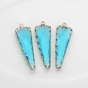 Detalle de colgantes de cristal azul claro triangulares con borde dorado claro