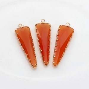 Lote de tres colgantes de cristal naranja facetado con borde de metal dorado