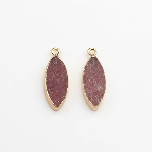 Detailweergave van donkerroze druzy marquise-hangers met vergulde randen