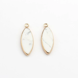 Macro-opname van marquise-vormige witte turkoois hangers met goudkleurige randen voor DIY