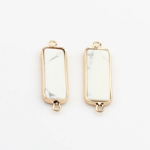 Dettaglio di pendenti rettangolari in howlite bianca placcati in oro con due anelli