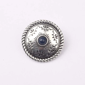 Dettaglio bottone vintage in lega d'argento con pietra blu e incisioni tribali