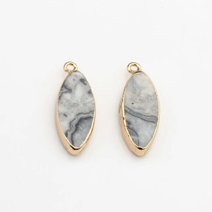 Detail van twee marquise natuursteen hangers met goudkleurige rand voor DIY sieraden
