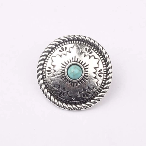 Dettaglio di un bottone rotondo vintage in argento con intarsio in turchese