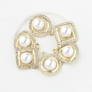 Macro shot of assorted geometric pearl charms with gold plating and rhinestone accents