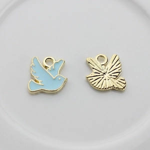 Détail du pendentif oiseau en émail bleu avec revers en métal doré texturé